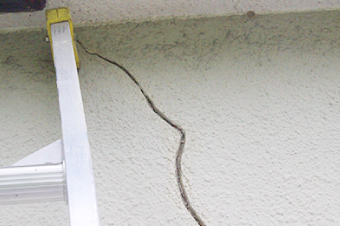 大きなクラックが目立つ白い外壁